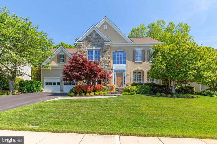 large home with surrounding colorful trees and flowers